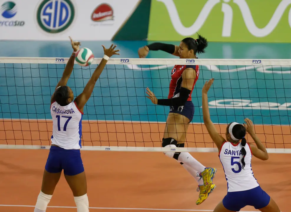 Fotograf&iacute;a de archivo de la dominicana Lisvel Eve Mej&iacute;a, quien remata ante las cubanas Heidy Casanova (i) y Yamila Hern&aacute;ndez Santas. Mej&iacute;a dio positivo en una prueba de dopaje y se perder&aacute; los Juegos Ol&iacute;mpicos. EFE/Orlando Barr&iacute;a