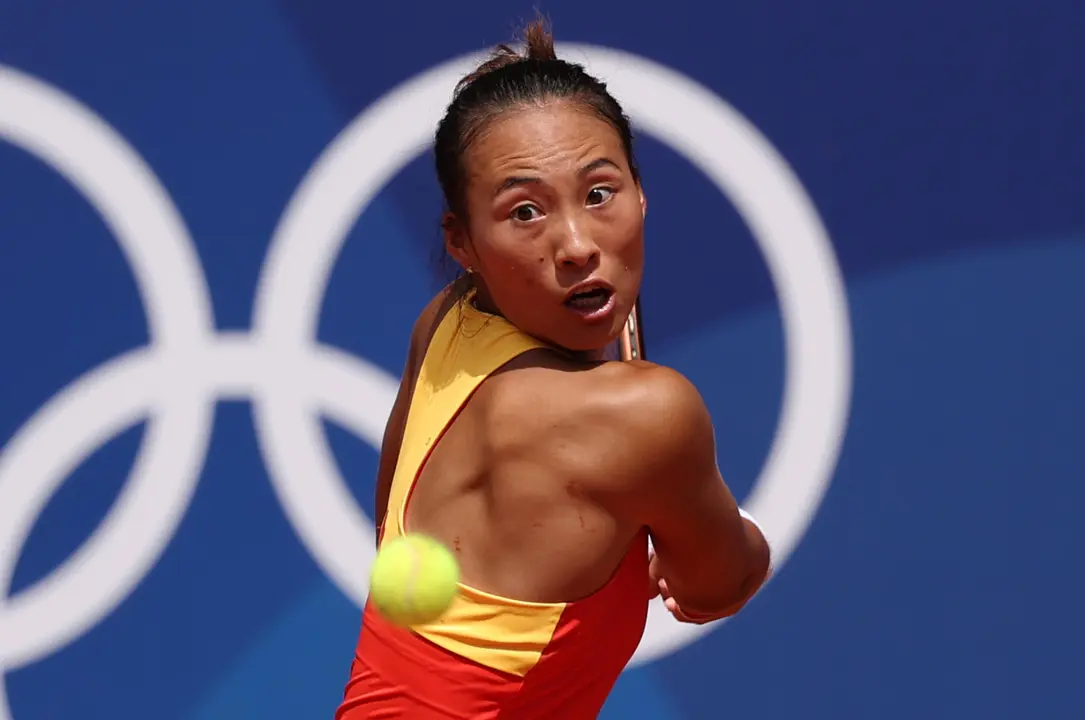 La tenista china Quinwen Zheng devuelve la bola a la polaca Iga Swiatek durante la semifinal femenina de tenis que enfrento a ambas en el marco de los Juegos Ol&iacute;mpicos Par&iacute;s 2024. EFE/ Juanjo Martin