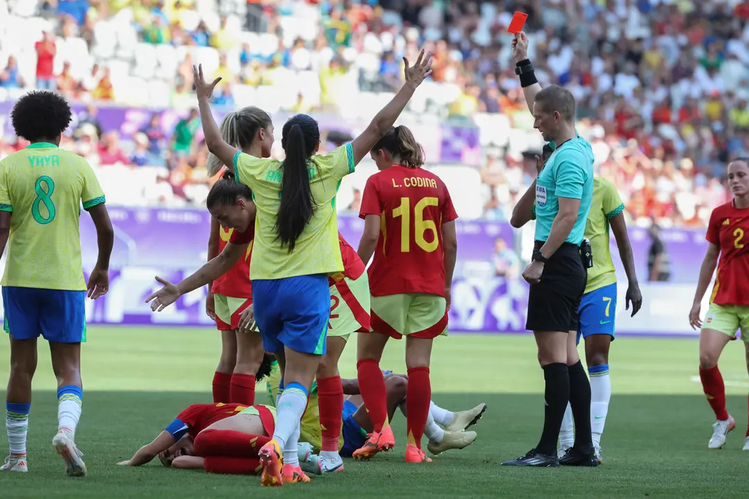 El &aacute;rbitro Espen Nor (d) saca tarjeta roja a la delantera brasile&ntilde;a Marta tras la falta realizada a la defensa espa&ntilde;ola Olga Carmona, en el partido del Grupo C del torneo ol&iacute;mpico de f&uacute;tbol, disputado en el Estadio de Burdeos (Francia). EFE/ Kiko Huesca