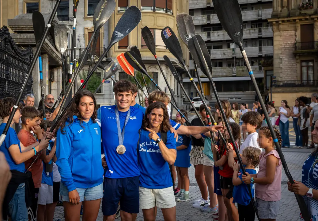 El pirag&iuml;sta donostiarra Pau Etxaniz (c), que ha obtenido la medalla de bronce en la prueba de K1 de pirag&uuml;ismo eslalon de los Juegos de Par&iacute;s 2024, durante un acto de bienvenida a los deportistas ol&iacute;mpicos del Club Atl&eacute;tico San Sebasti&aacute;n celebrado este martes, junto a la pirag&uuml;istas Maialen Chourraut (d), oro en R&iacute;o 2016, entre otras medallas, y Miren Lazkano (i), finalista en Par&iacute;s. EFE/Javier Etxezarreta