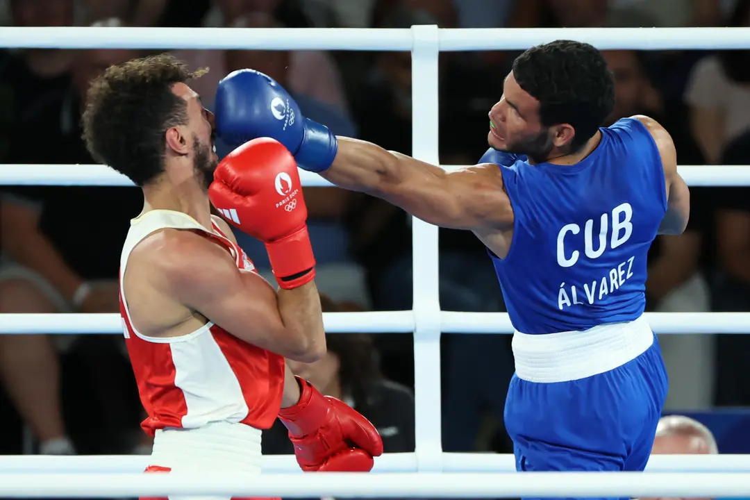El boxeador franc&eacute;s Sofiane Oumiha (rojo) combate con el cubano Erislandy &Aacute;lvarez durante la final masculina de Boxeo 63.5kg de los Juegos Ol&iacute;mpicos de Par&iacute;s 2024 este mi&eacute;rcoles, en el Estadio Roland-Garros de la capital gala. EFE/ Kiko Huesca