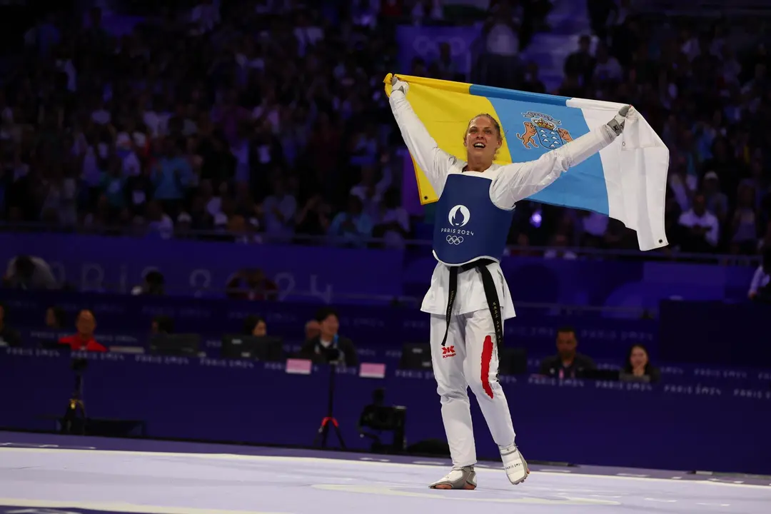 La h&uacute;ngara Viviana Marton, que se proclam&oacute; campeona ol&iacute;mpica en taekwondo, en la categor&iacute;a de -67 kilos, sorprendi&oacute; al t&eacute;rmino de su combate con la croata Aleksandar Perisic en la final y sobre el tapiz, sac&oacute; la bandera de Canarias, donde ha vivido su infancia. EFE/EPA/DIVYAKANT SOLANKI