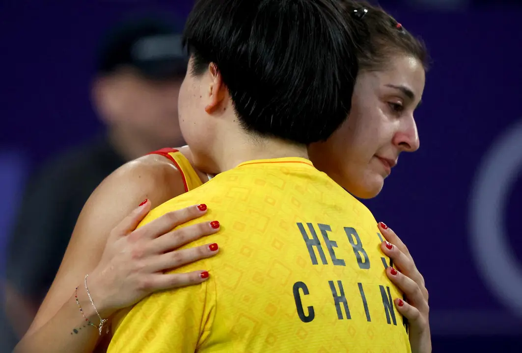 Carolina Mar&iacute;n consolada por la jugadora china He Bing Jiao, tras verse obligada a retirarse por una lesi&oacute;n en la semifinal individual del b&aacute;dminton den los Juegos Ol&iacute;mpicos de Par&iacute;s 2024. EFE/EPA/DIVYAKANT SOLANKI