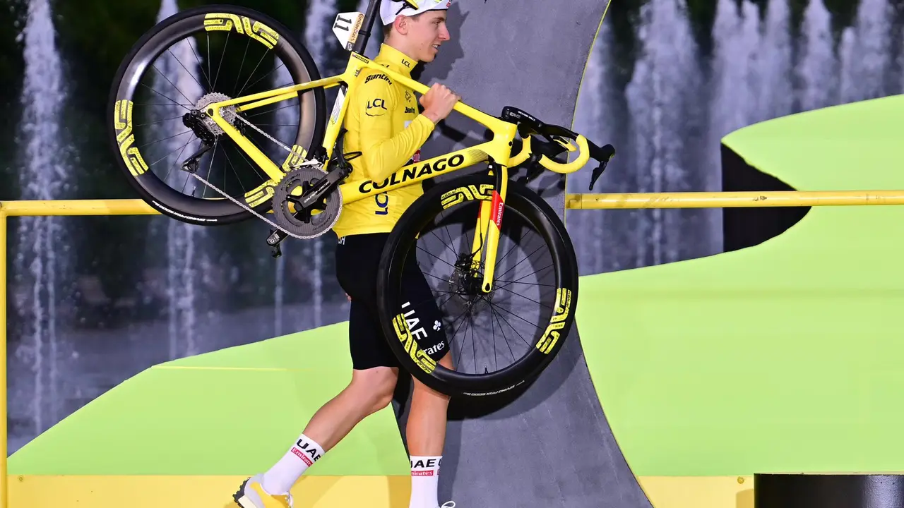 El cliclista esloveno Tadej Pogacar del equipo UAE carga su bicicleta al podio de ganadores luego de vencer en la etapa 21 del Tour de Francia 2024 este domingo, en Niza (Francia). EFE/EPA/PAPON BERNARD