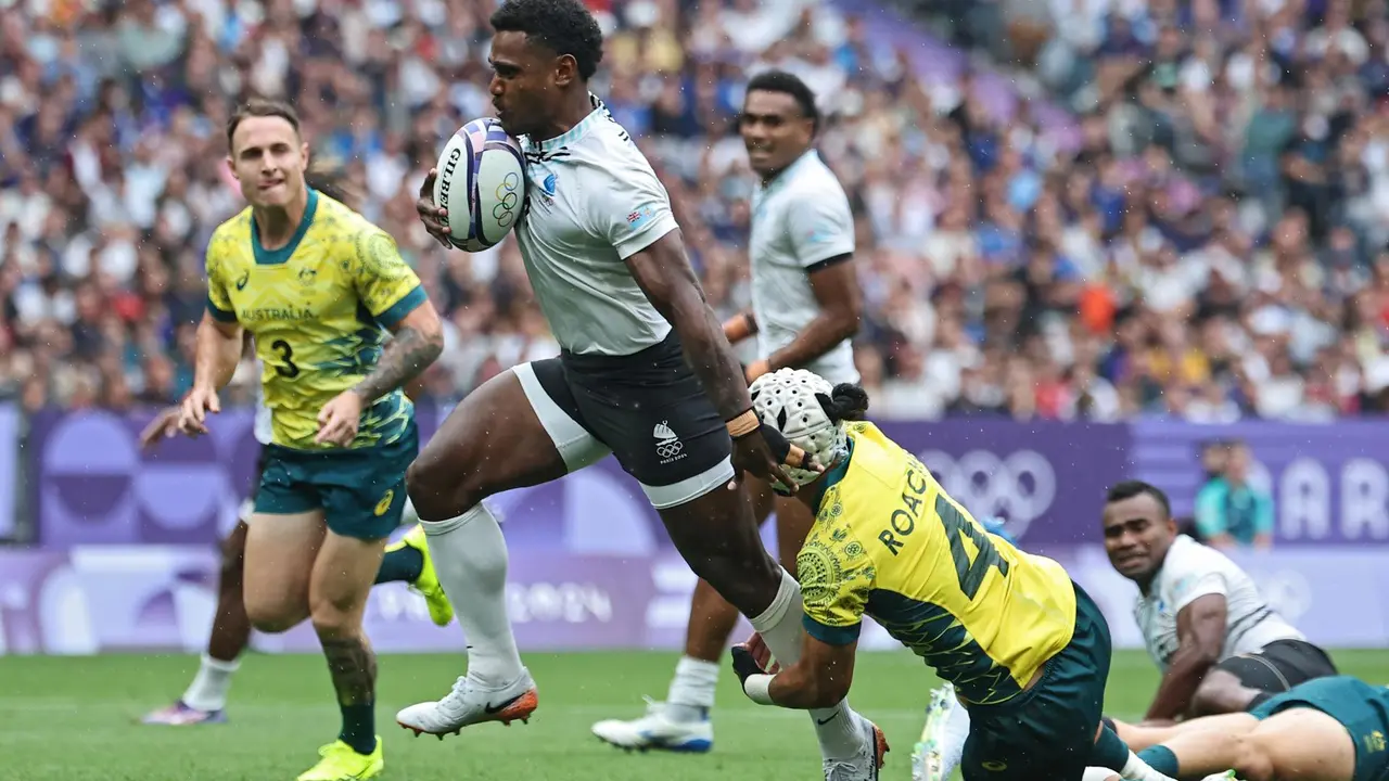 El jugador Jerry Tuwai, de Fiji, deja a tr&aacute;s al australiano durante el partido de semifinales que han jugado Fiji y Australia en el Stade de France en Saint Denis, Francia. EFE/EPA/CHRISTOPHE PETIT TESSON