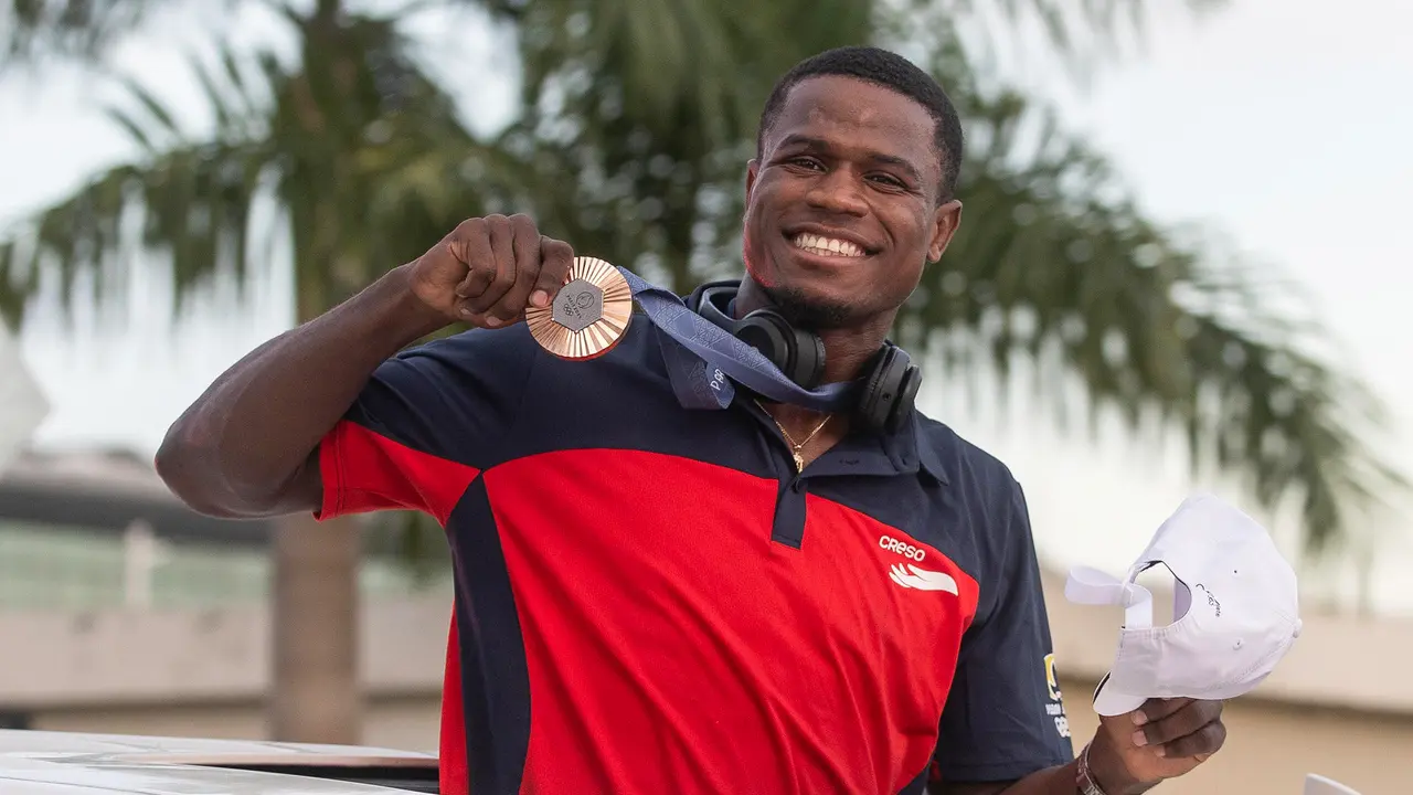 El boxeador Cristian Pinales, medallista de bronce en boxeo en los Juegos Ol&iacute;mpicos de Par&iacute;s 2024, saluda durante su recibimiento,en el Aeropuerto Internacional de las Am&eacute;ricas, en Santo Domingo (Rep&uacute;blica Dominicana). EFE/Orlando Barr&iacute;a