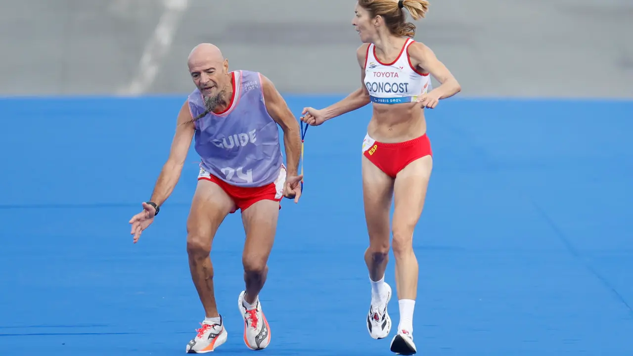 La atleta espa&ntilde;ola Elena Congost, medalla de bronce en la final de la marat&oacute;n T12 femenino, ayuda a su gu&iacute;a, que llega exhausto a la l&iacute;nea de meta, este domingo en los Juegos Paral&iacute;mpicos de Par&iacute;s 2024. EFE/ Javier Etxezarreta